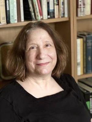 professor in a black shirt in front of a bookcase
